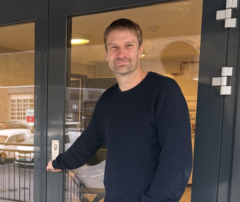 Ola Inge Sæther Mann med blå genser står ve din inngangsdør til et bygg