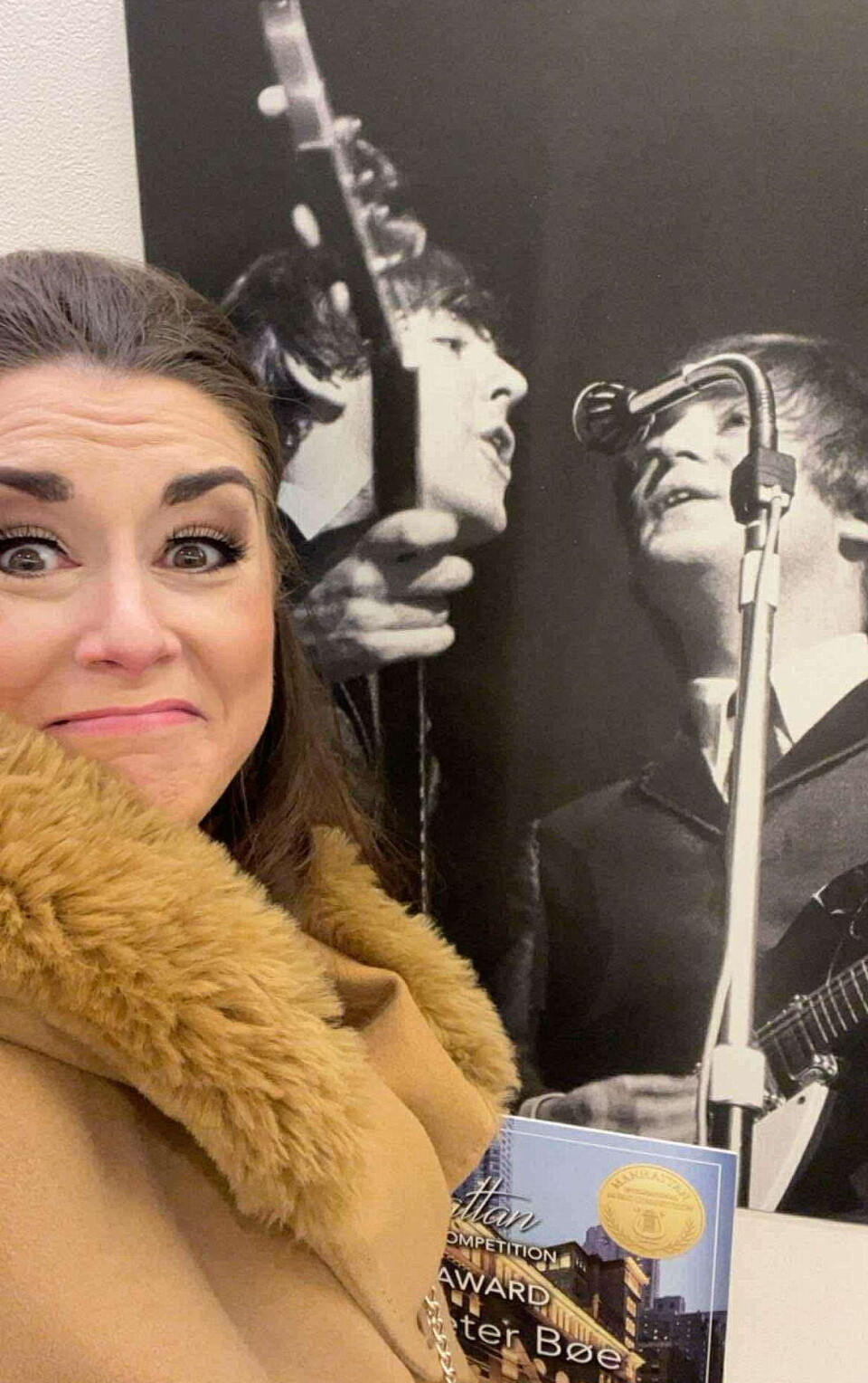 Det har vore kjentfolk i Carnegie Hall før og... Ei dame foran et stort gammelt bilde av to av medlemmene i The Beatles.