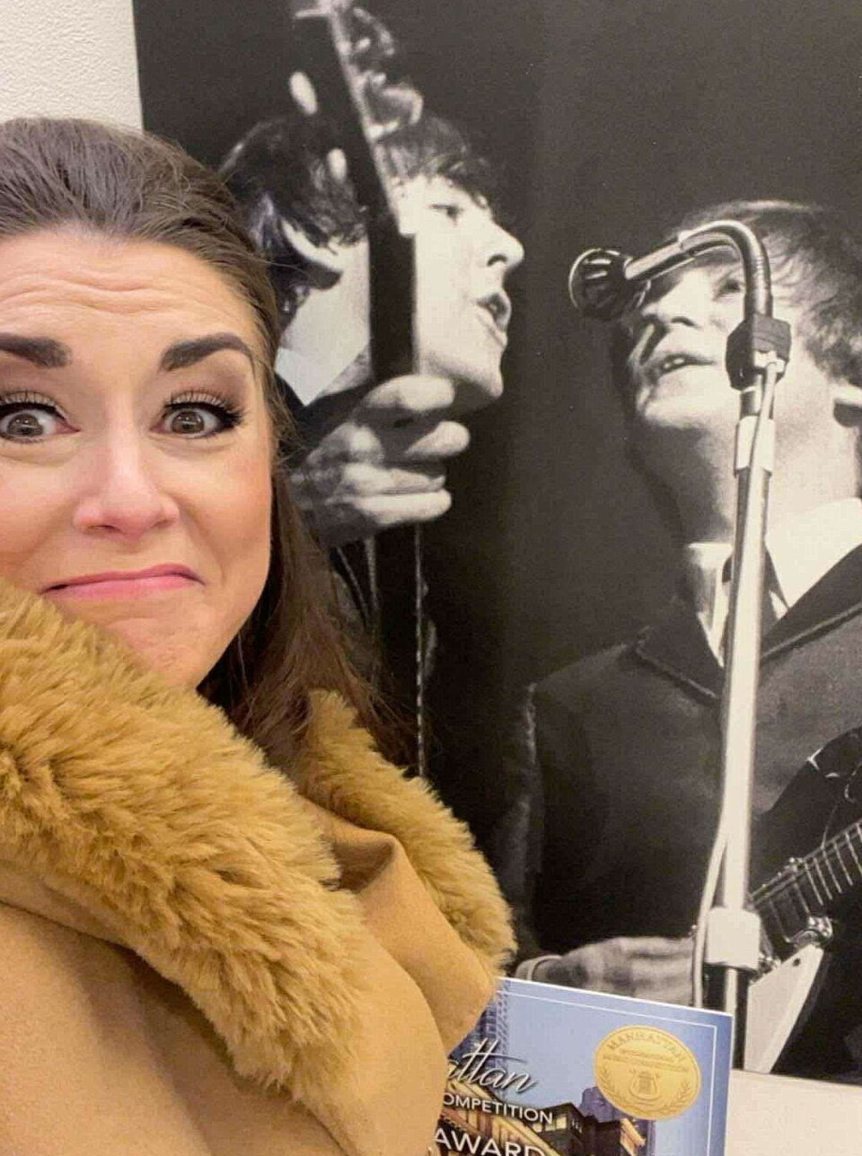 Sigrid Vetleseter Bøe skal delta på gallakonserten i sjølvaste Carnegie Hall. Ei dame foran et stort gammelt bilde av to av medlemmene i The Beatles.