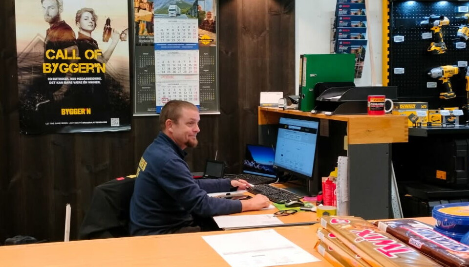 Jan Bjørnbeth jobber også på Bygger`n Rindal Her er en mann som sitter bak en disk foran en pc, ved disken er det en hylle med forskjellige verktøy.