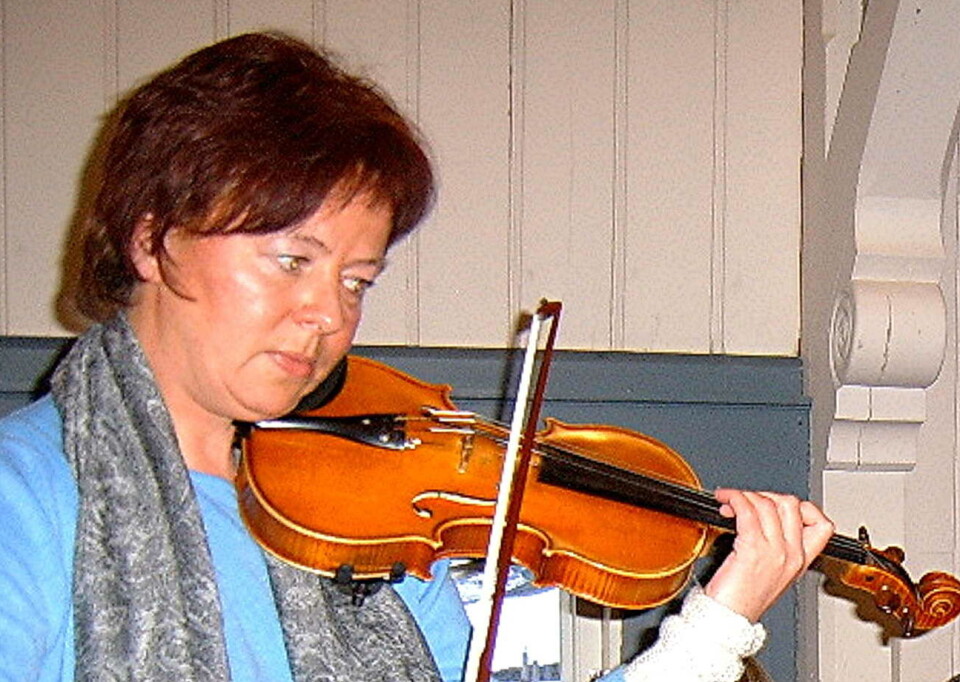 Konsertens førstefiolinist – Synnøve Hammervold. Ei dame med mørkt kort hår, som spiller fiolin.