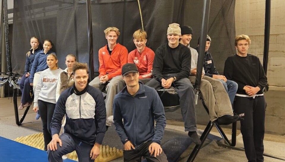Surnadal IL Freeski avholdt trampolinekurs i Rindal Næringsbygg i helgen. Bildet viser en stor gjeng unge mennesker i et stort lagerbygg. De står foran en stor trampoline, og i front ser vi en turnmatte liggende på gulvet.