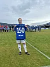 fotballspiller med blå skjorte med 150 på