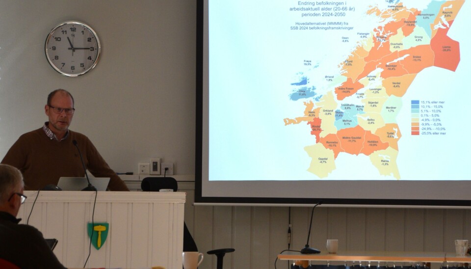 Kommunedirektør Mons Otnes viste et kart over forventet befolkningsutvikling i Trøndelag fram mot år 2050. Størst skjevfordeling mellom unge og eldre forventes i Rindal og i Lierne. En mann som står på en talerstol og snakker til en forsamling. Ved siden av han et kart vist på et lerret med projektor.