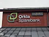 Rød vegg med lysskilt med tekst Orkla Sparebank