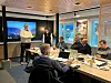 Flere personer rundt et bord i et møtterom.