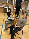 To jenter som sitter som dommere på volleyball.