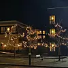 Julelys utendørs og adventstjerner i flere vinduer.