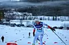 Jente i hvit skidress skøyter på ski