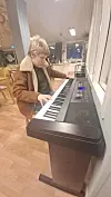 En ung gutt sitter ved elektrisk piano og spiller i et lyst lokale.