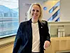 Ingvil Dalseg står smilende i et lyst møterom ved en talerstol.