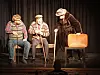 Tre skuespillere som spiller eldre menn med stokker på liten teaterscene.