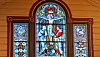 Glassmaleri med religiøst motiv i buet kirkevindu