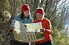 To kvinner ute i skogen som ser på et stort turkart sammen