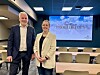 To personer i konferansesal foran stort lerret med Trollheimen-presentasjon.