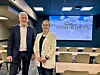 To personer i konferansesal foran stort lerret med Trollheimen-presentasjon.