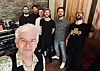 Gruppe musikere smiler og poserer i et innspillingsstudio
