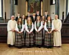 Gruppebilde av konfirmantar og to kyrkjelege leiarar framfor alteret i Stangvik kyrkje.