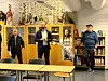 Fire personer står i et utstillingsrom med kostymer, figurer og glassmontrer langs veggen.