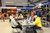 Fire personer sitter rundt et bord i en sportsbutikk med sportsutstyr og Polaris-produkter i bakgrunnen.