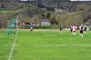 Fotballspillere ved målområdet på en gressbane, med keeper og mål til venstre.