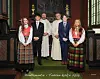 Fem ungdommer og to geistlige står oppstilt foran alteret i en kirke.
