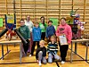 Barn og to damer foran to kreative prototyper laget av diverse rør, papp og kosedyr.