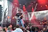 Band spiller live på en utendørsscene foran et publikum i kveldsmørket.