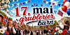 17. mai-feiring med flagg, bunadskledde personer, ballonger og festpynt i en bygate.