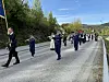 Et 17. maitog går langs en landevei med korps, flagg og mange deltakere.