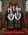 Fem festekledde konfirmanter og to geistlige står foran alteret i en kirke.