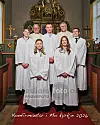 Fem ungdommer i hvite kapper og to geistlige står foran alteret i en kirke.