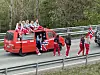 En rød russebil med folk på taket.