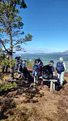 Turgruppe på en skogkledd utsikt med ryggsekker og panoramautsikt over fjell og vann.