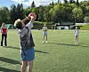 Barn på en kunstgressbane spiller med en fargerik ball i luften.