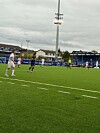 Fotballspillere på en kunstgressbane under overskyet vær.