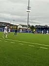 Fotballspillere på en kunstgressbane under overskyet vær.