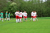 To fotballag i rødt og hvitt står samlet på en grønn fotballbane.
