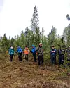 Ei gruppe turgåere i skogen i regnvær.