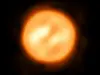 Nærbilde av den røde superkjempestjernen Antares, vist som en lys oransje skive mot svart bakgrunn.