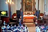 Utsikt over en kirke med forsamling, alter og en person som står foran koret.