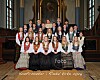 En gruppe konfirmanter i bunader og dresser står samlet i en kirke foran alteret.