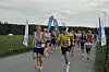 En gruppe løpere starter i et løp på en landevei.