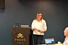 Kvinne holder en presentasjon ved en talerstol med Frich’s-logo i et møterom.