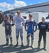 Fire unge gutter, noen av dem i motocrossklær, oppstilt ved siden av hverandre for fotografering.
