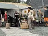 Personer i utkledningsklær opptrer utendørs. En musiker i vanlige klær.