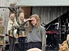 Skuespiller og musiker opptrer utendørs foran instrumenter/lydutstyr.