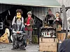 Fem personer på en scene med musikkutstyr. Fire er utkledd.