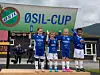 Unger på premieutdeling med fotballklær. ØSIL-banner i bakgrunnen.