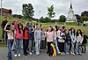 En gruppe mennesker står samlet utendørs foran en kirke og poserer for et gruppebilde.